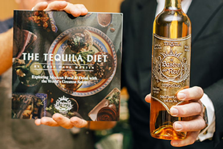 Persona sosteniendo una botella de tequila y un recetario