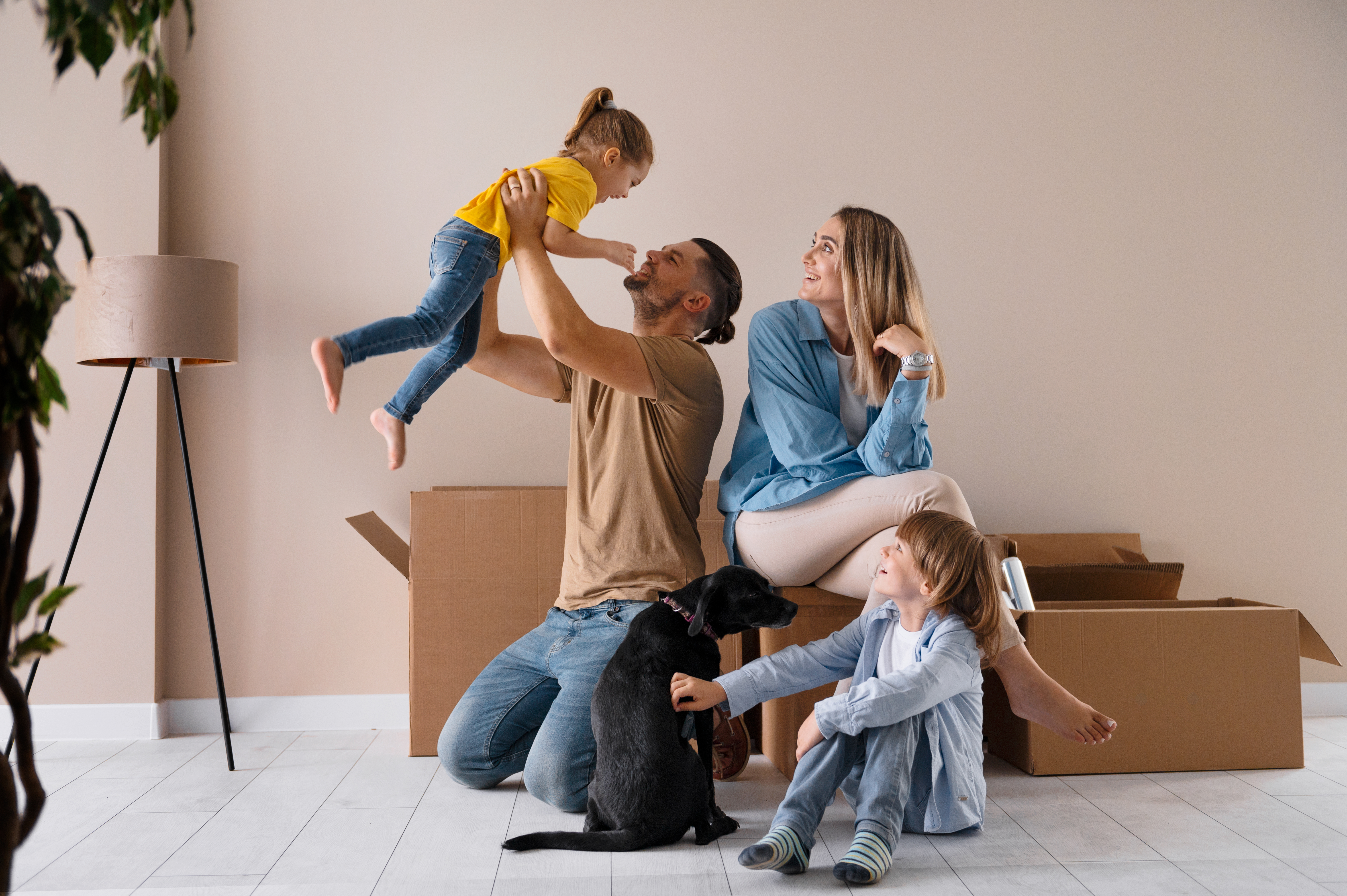 familia feliz con perro mudándose a una nueva casa con cajas de cartón y una lámpara Bodega Guadalajara