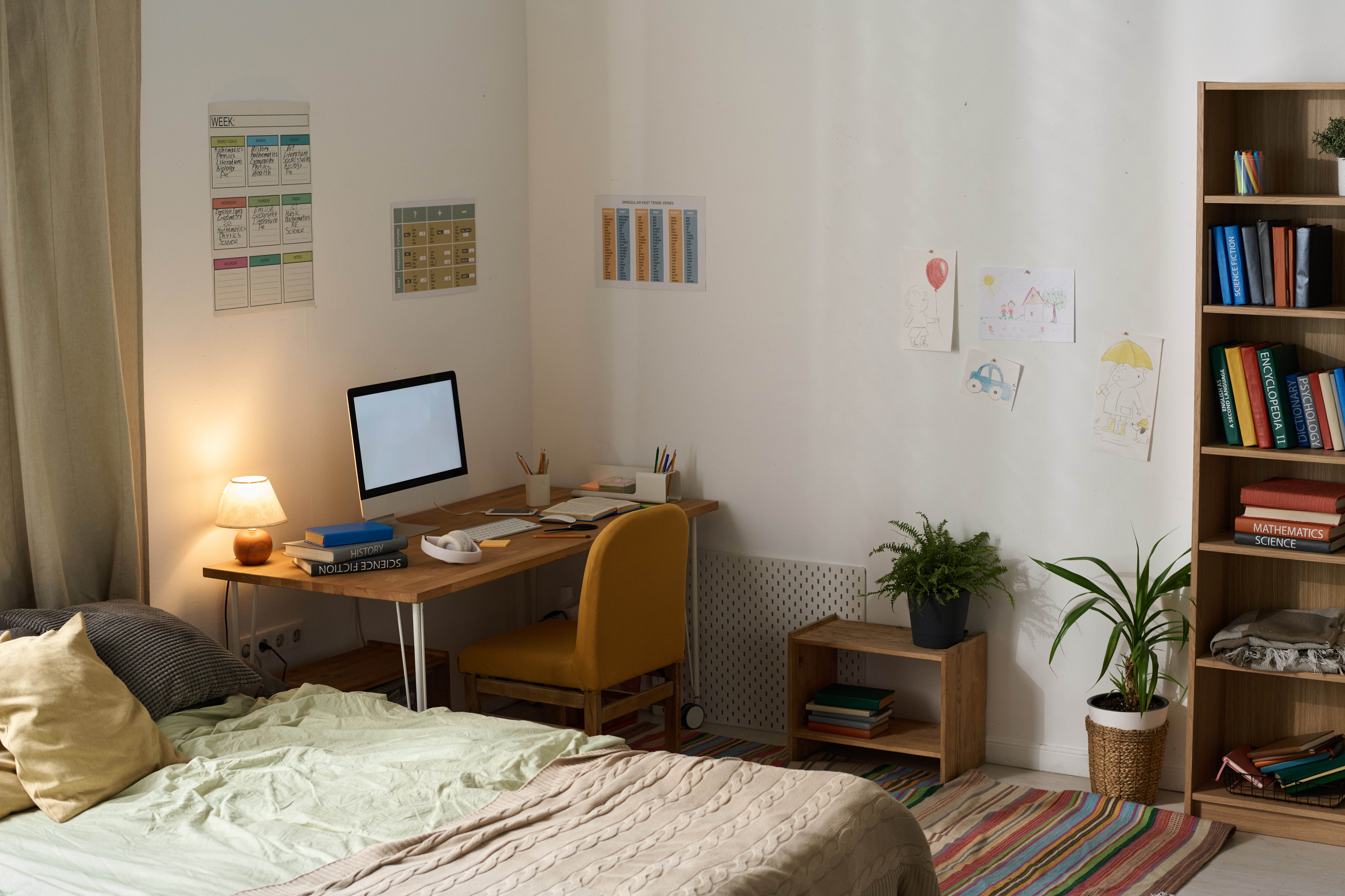 Modern room of teenager with workplace and computer monitor on it